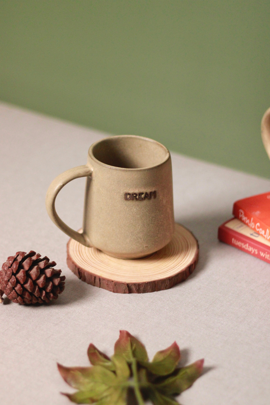 Dream coffee mug on wooden coaster