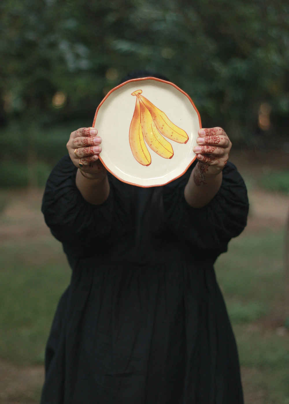 Someone showing banana plate on a garden
