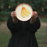 Someone showing banana plate on a garden