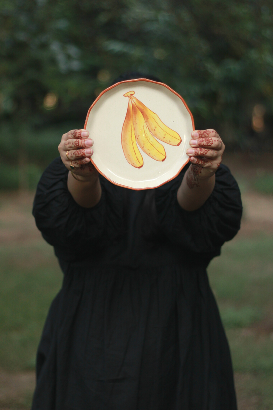 Someone showing banana plate on a garden