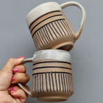 Brown carved coffee mug in hand
