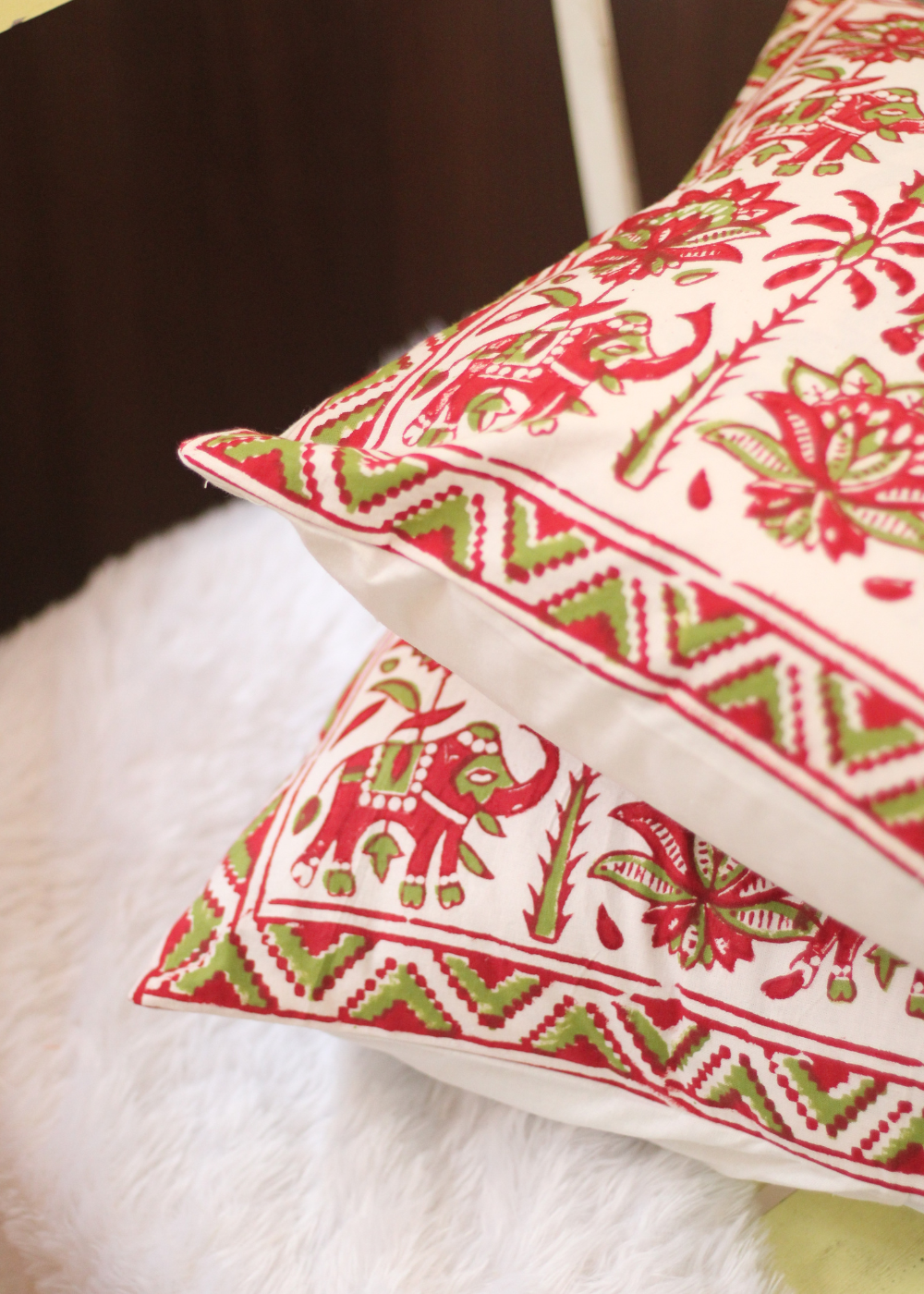 Two red elephant print cushions 