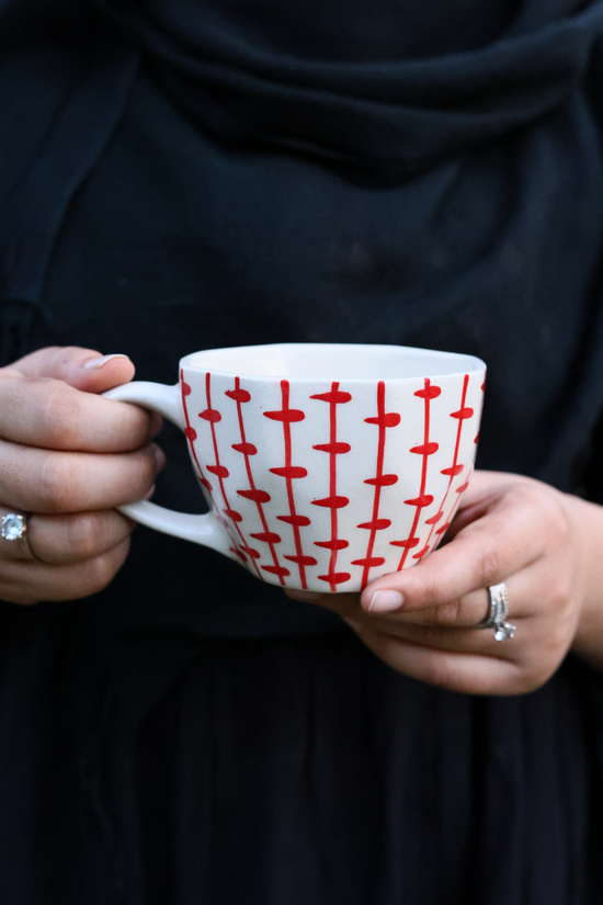 Red crosses mug in hand 