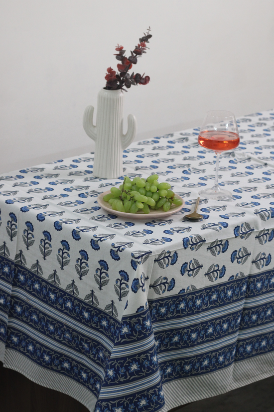 Blue motif table cloth on table with fruits & juice on it