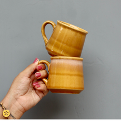 Mustard coffee mug in hand 