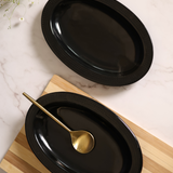 Two black oval bowl with spoon