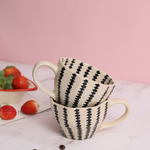 Black crosses coffee mug on each other with strawberries