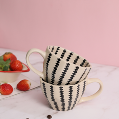Black crosses coffee mug on each other with strawberries