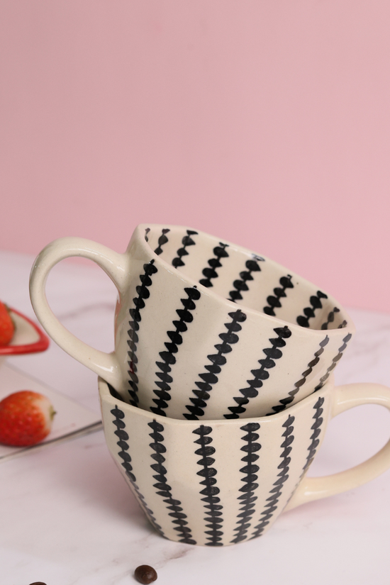 Black crosses coffee mug on each other with strawberries