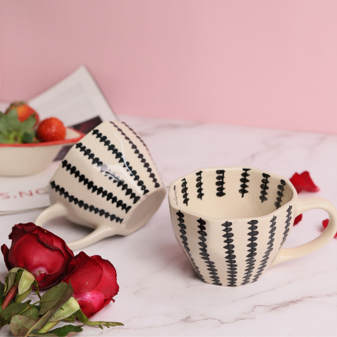 Two coffee mugs with roses and strawberries