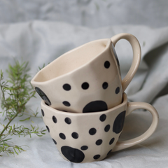 Two black polka white mug on each other
