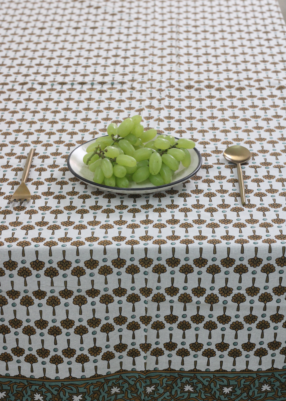 Floral table cloth with grapes and spoon