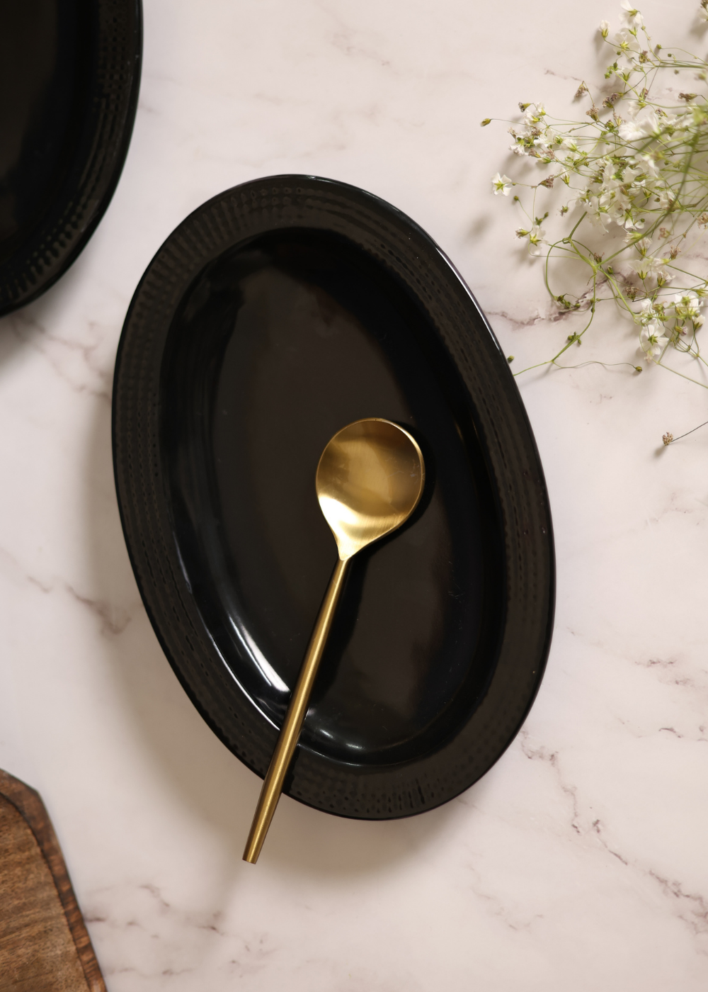 Black oval bowl with golden spoon