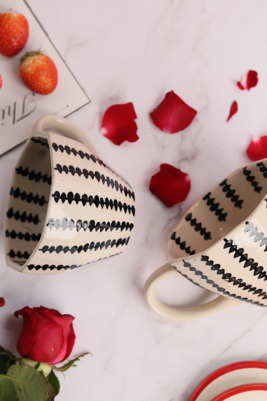 Two coffee mugs laying on the surface 