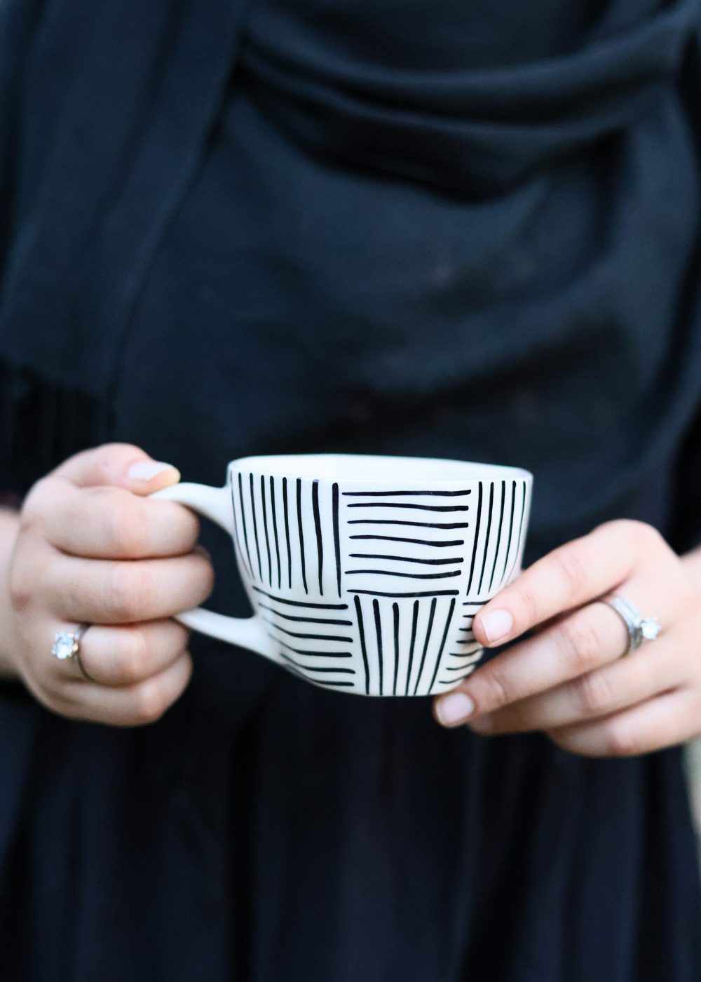 Black all lines coffee mug in a hand