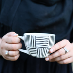 Black all lines coffee mug in a hand