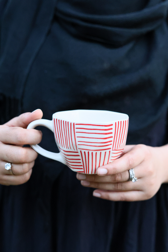 Handmade ceramic coffee mug in hand