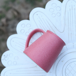 Pink coffee mug laying on a surface
