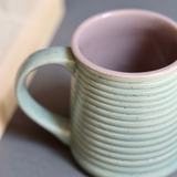 Glossy mint & grey coffee mug closeup shot
