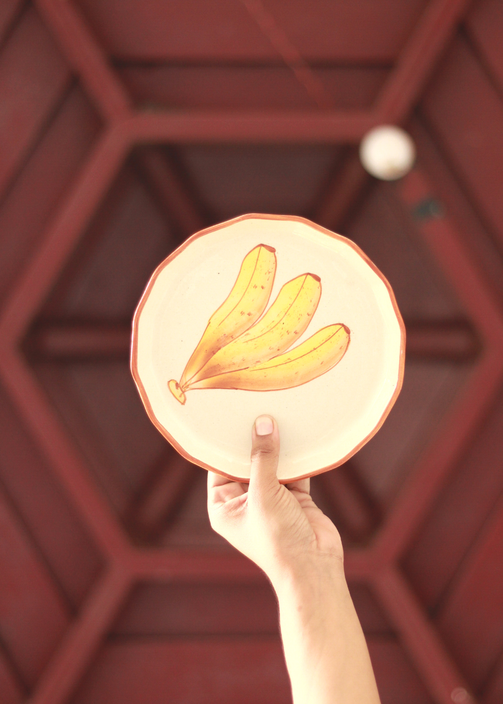 Someone holding a plate designed banana on it