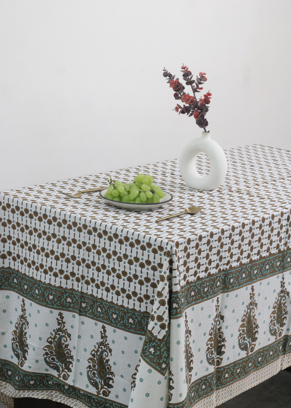 Green & brown floral table cloth with vase & fruits