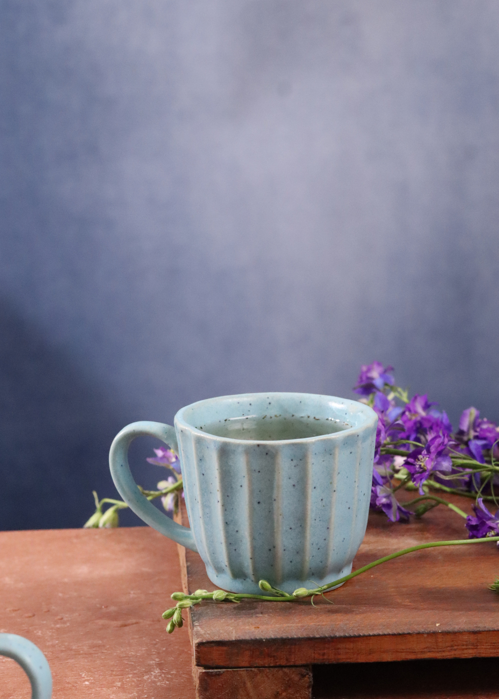 Sky blue chai cup with tea on a wooden surface