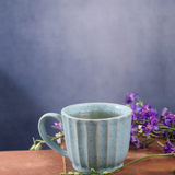 Sky blue chai cup with tea on a wooden surface