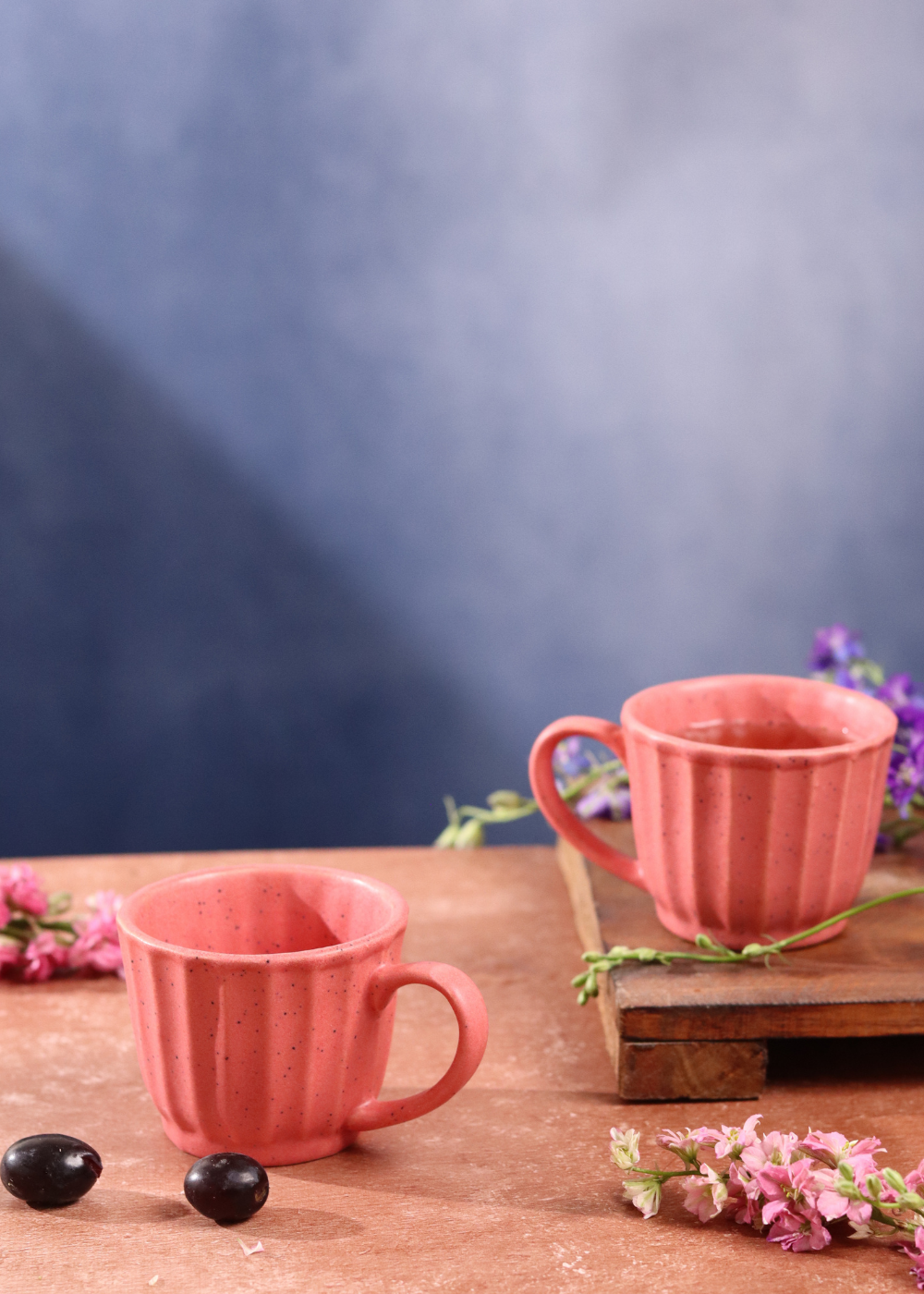 Two tea cups on one is on the wooden surface