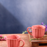 Two tea cups on one is on the wooden surface