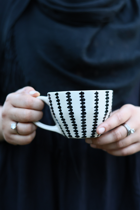 Black crosses mug in a hand