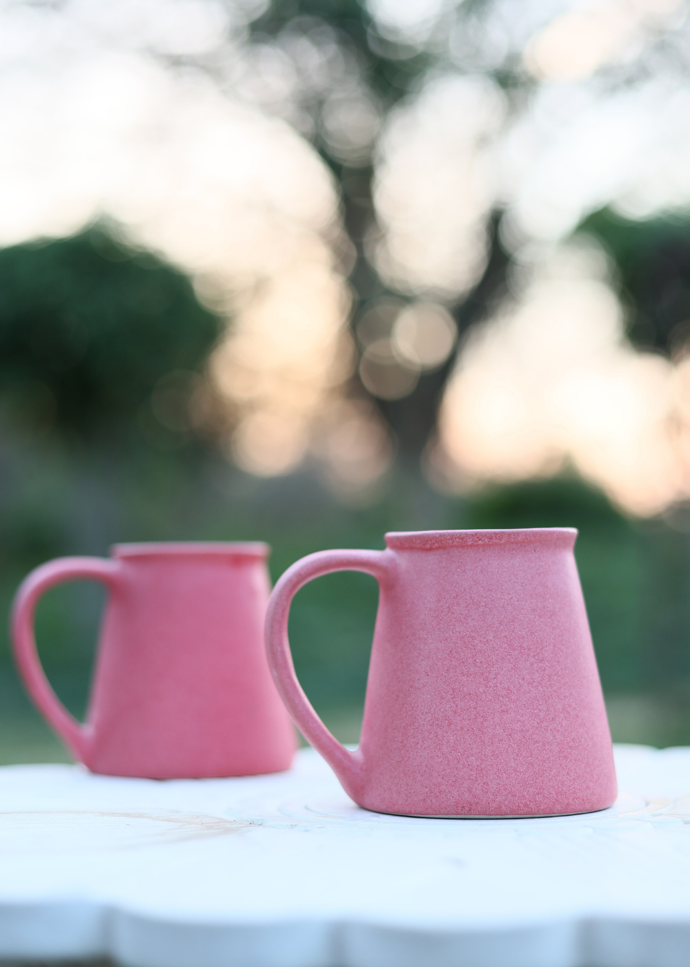 Two basic pink coffee mug in a open area