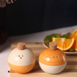 White & orange salt & pepper shakers with wooden lids