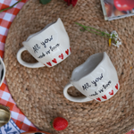 Two quoted coffee mugs and strawberry laying on a mat 