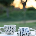 Handmade black dotted lines mug in different position