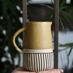 Brown carved jug on hand