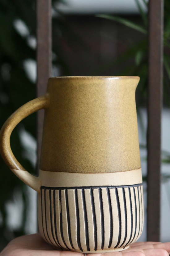 Brown carved jug on hand