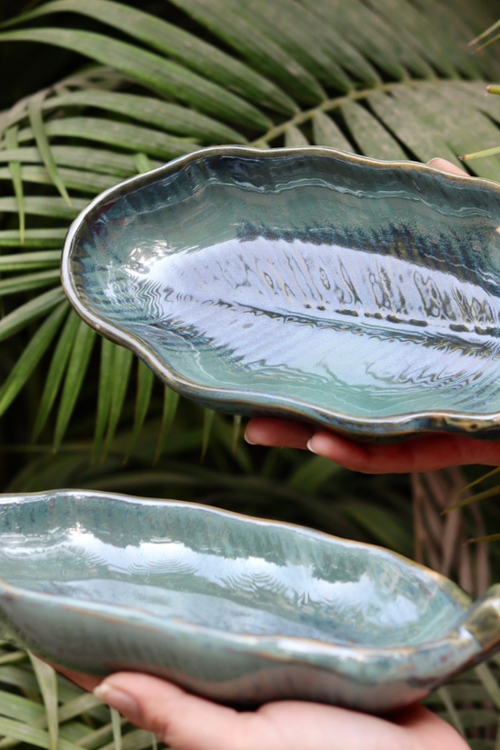 Two ceramic platters in hand 