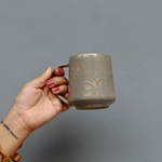 Grey leaf coffee mug in hand 