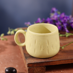 Mellow yellow chai cup on wooden surface