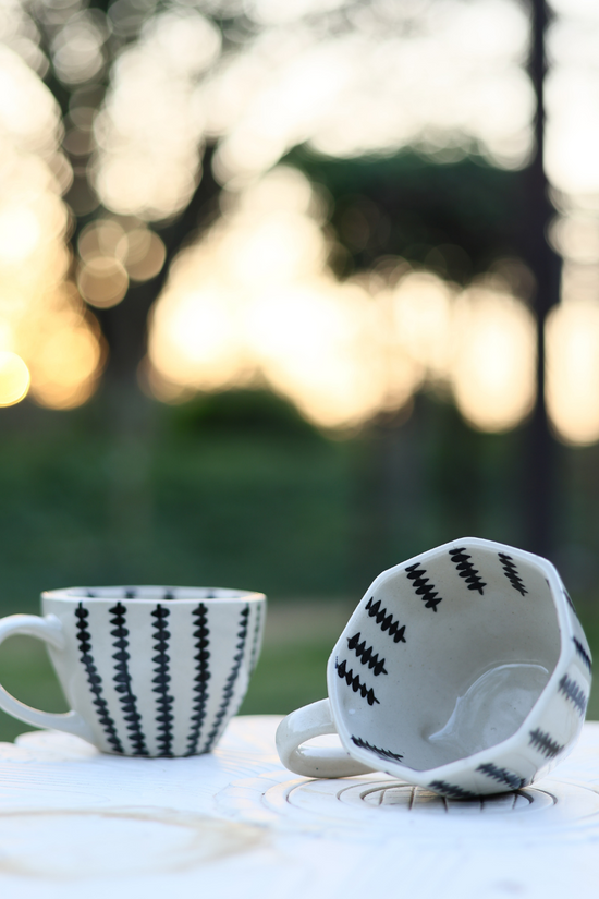 Two coffee mugs in a garden