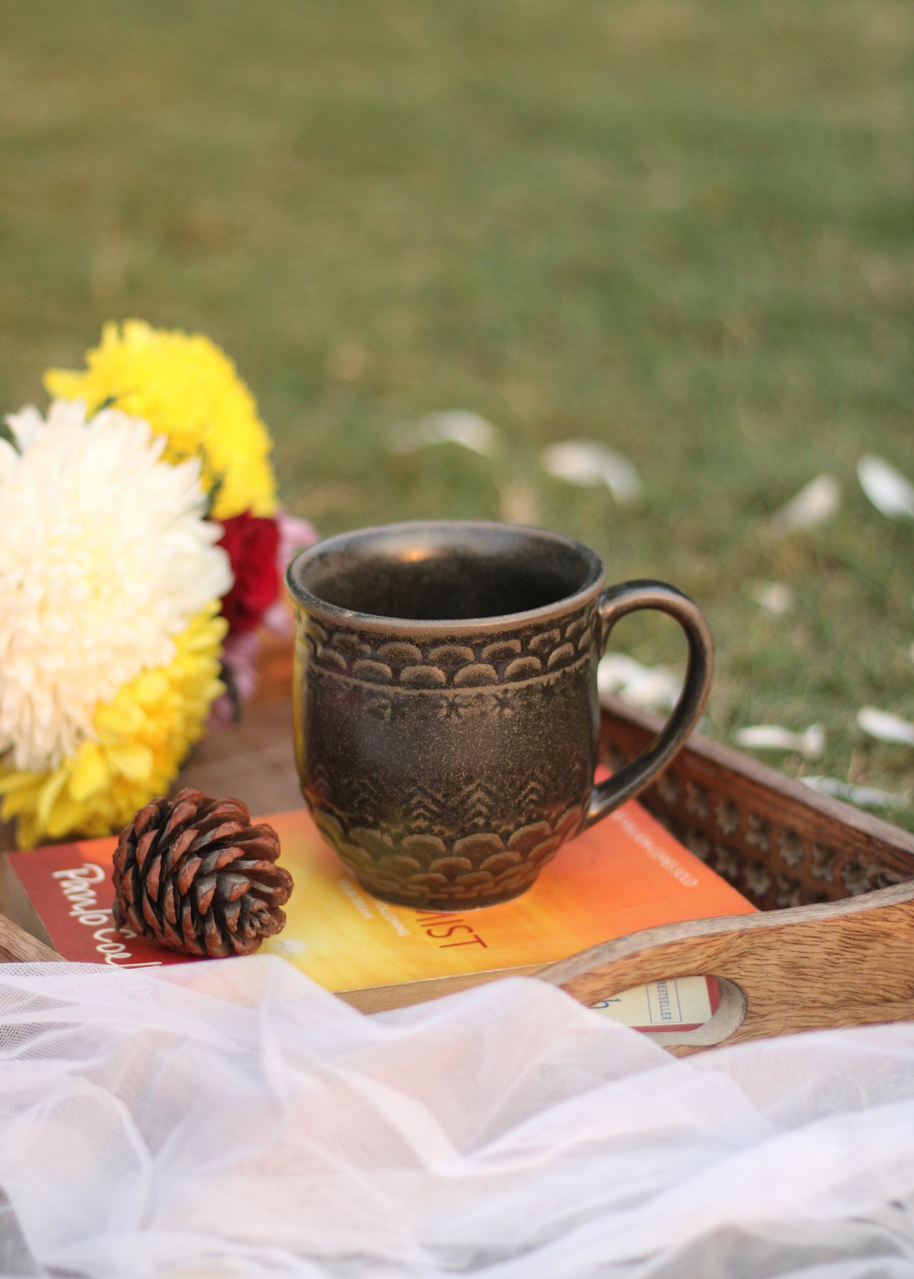 Black coffee mug in a wooden tray with flowers