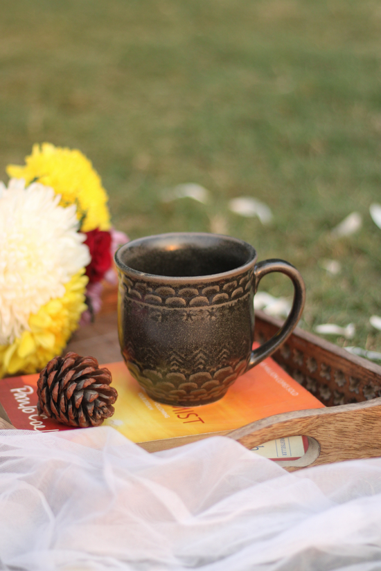 Black coffee mug in a wooden tray with flowers