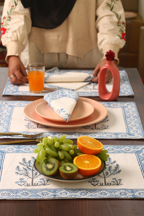 Someone is setting a table with fuits and juice