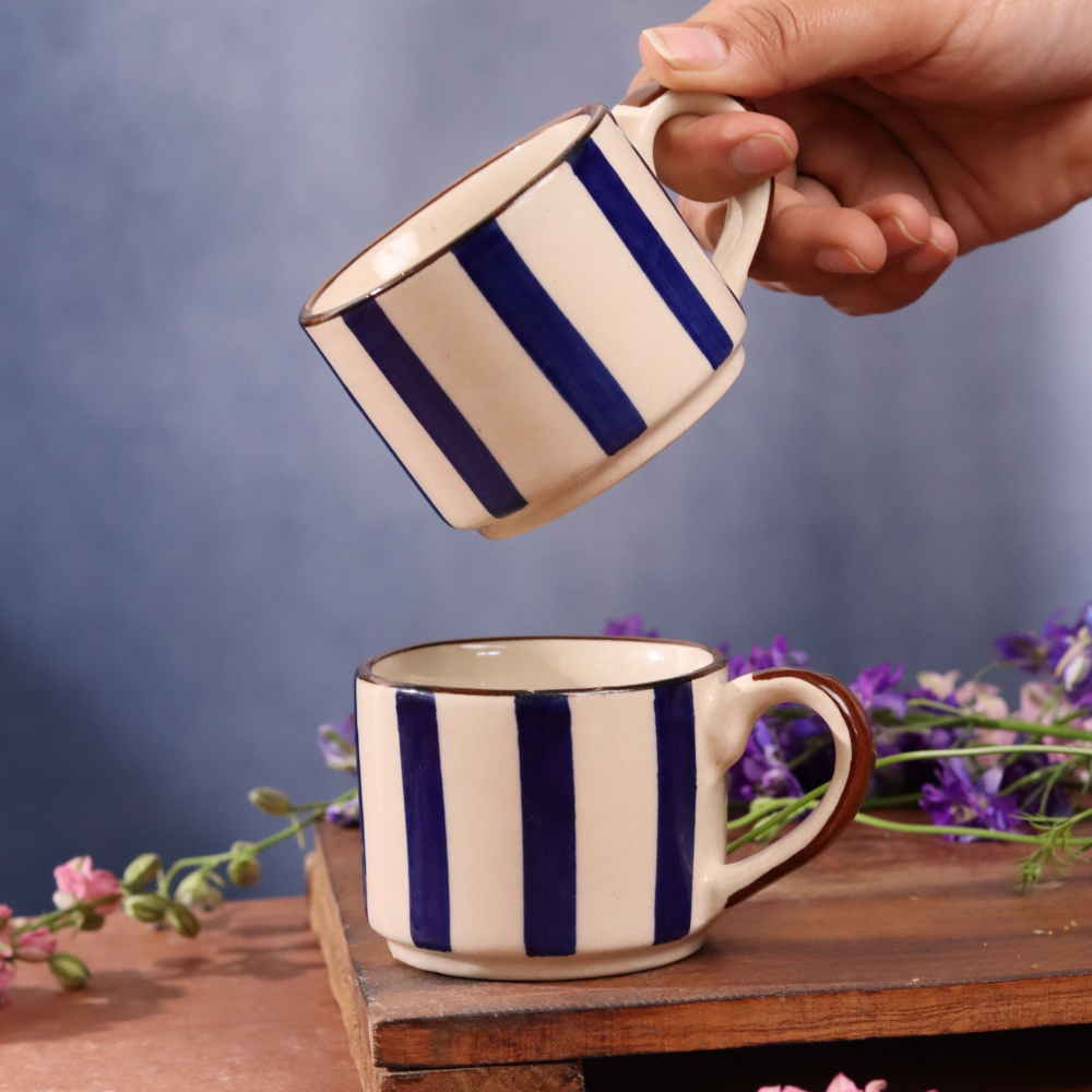 Blue striped chai cups in hand
