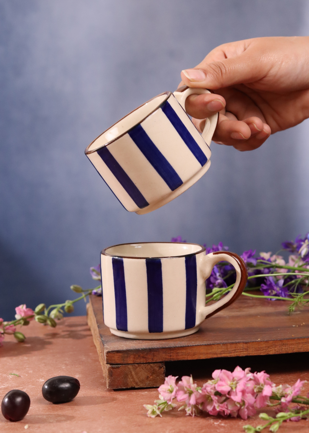 Blue striped chai cups in hand