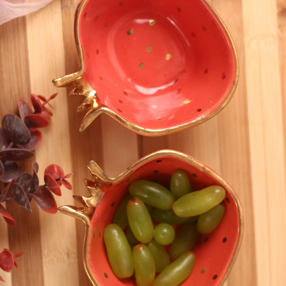 Two red anar bowls one has grapes