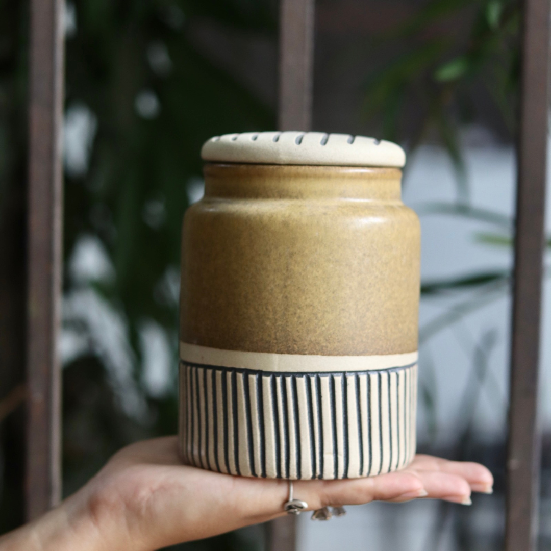 Brown carved storage jar in hand