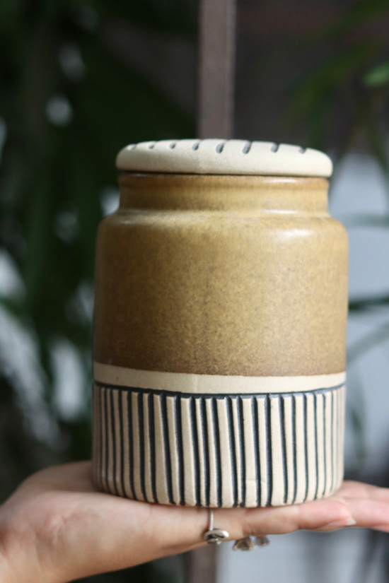 Brown carved storage jar in hand
