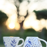 Two blue leaf coffee mug in garden