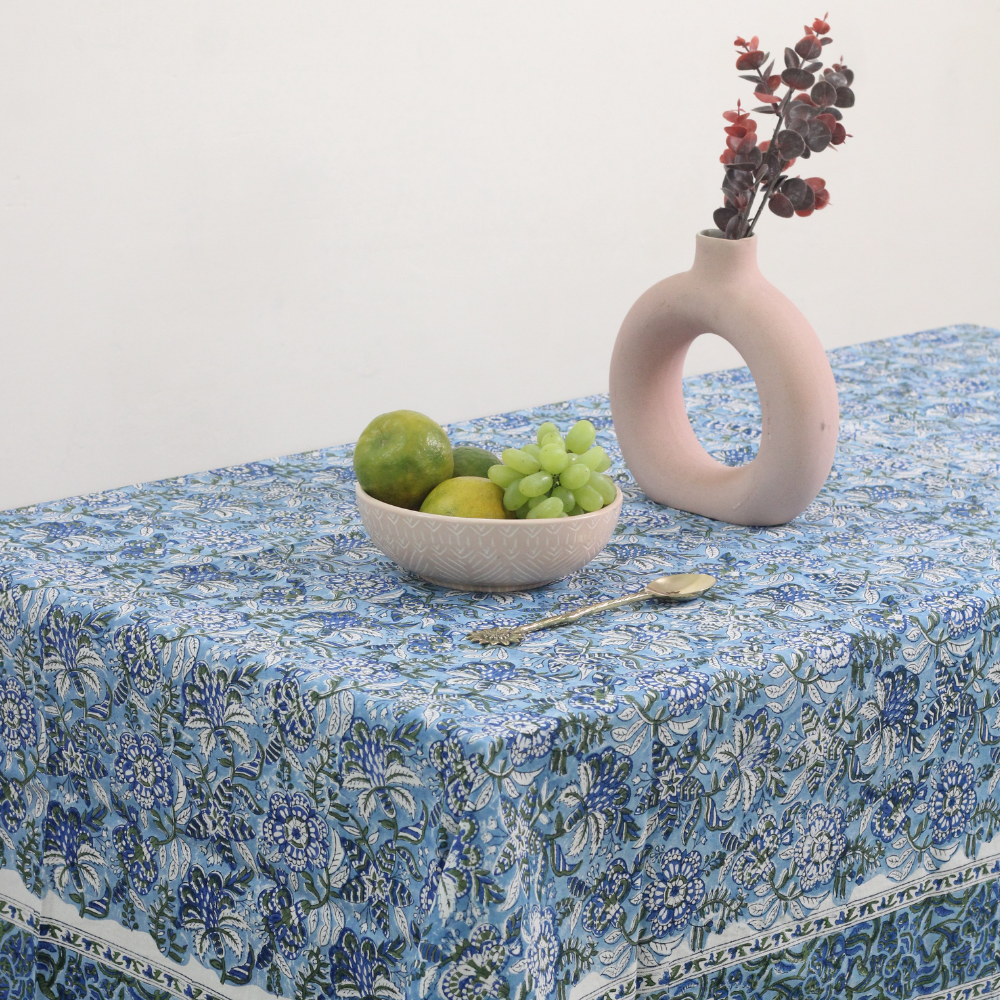 Blue floral table cloth with vase and fruits